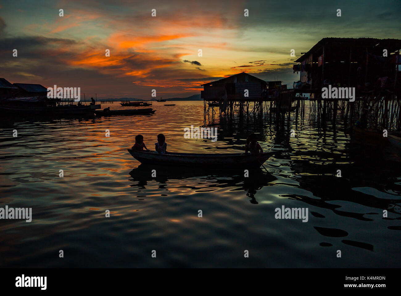 Semporna, Sabah, Mai 2017, Golden Sunset mit Mann auf Boot Hintergrund Der bajau Stelzenhaus Stockfoto
