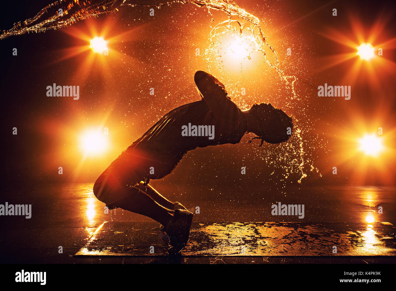 Junger Mann Breakdancer mit Licht- und Wassereffekte. Tattoo auf der Hand. Stockfoto