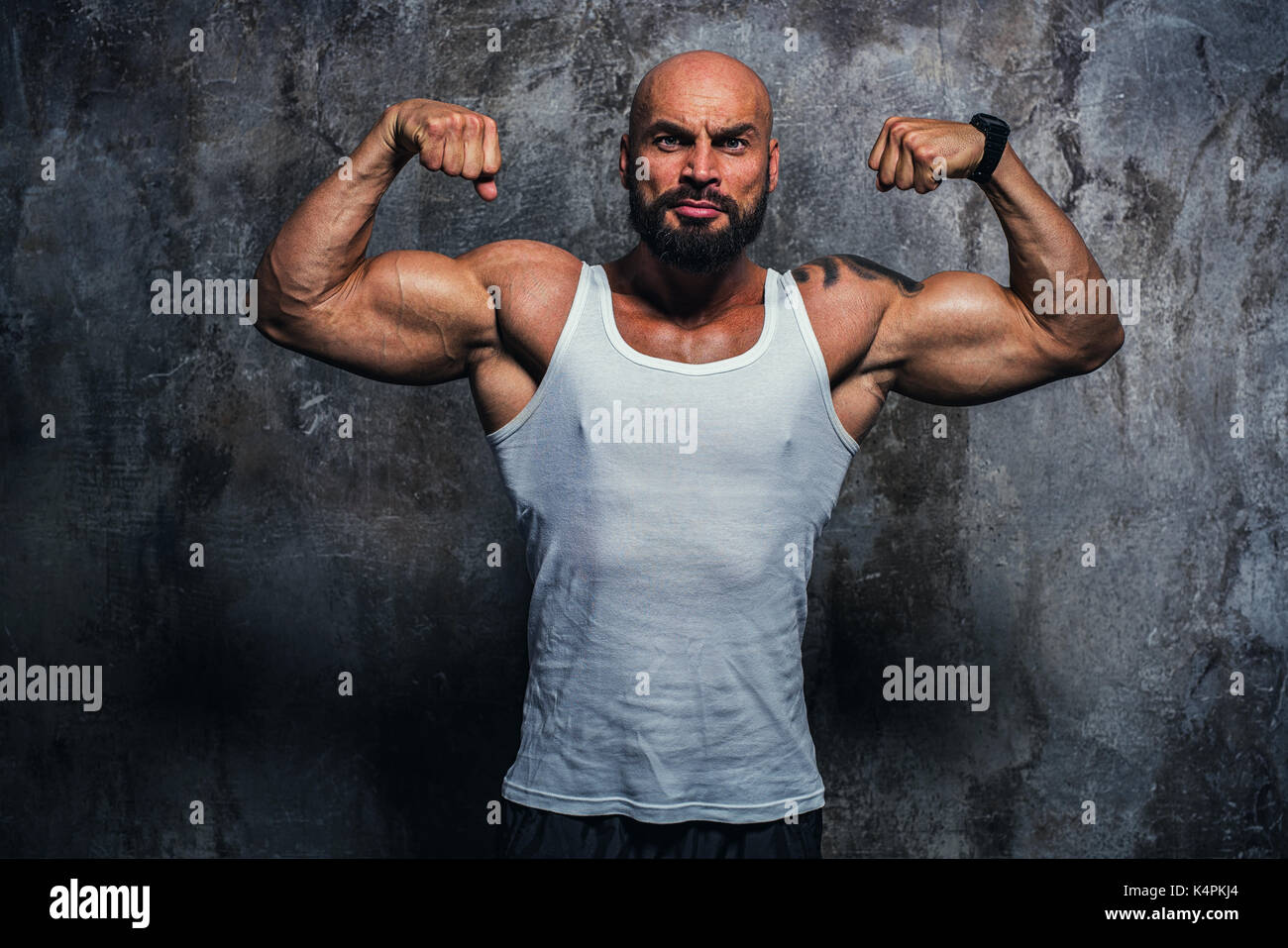 Starke mann Bodybuilder auf Wand Hintergrund. Tattoo am Körper. Stockfoto