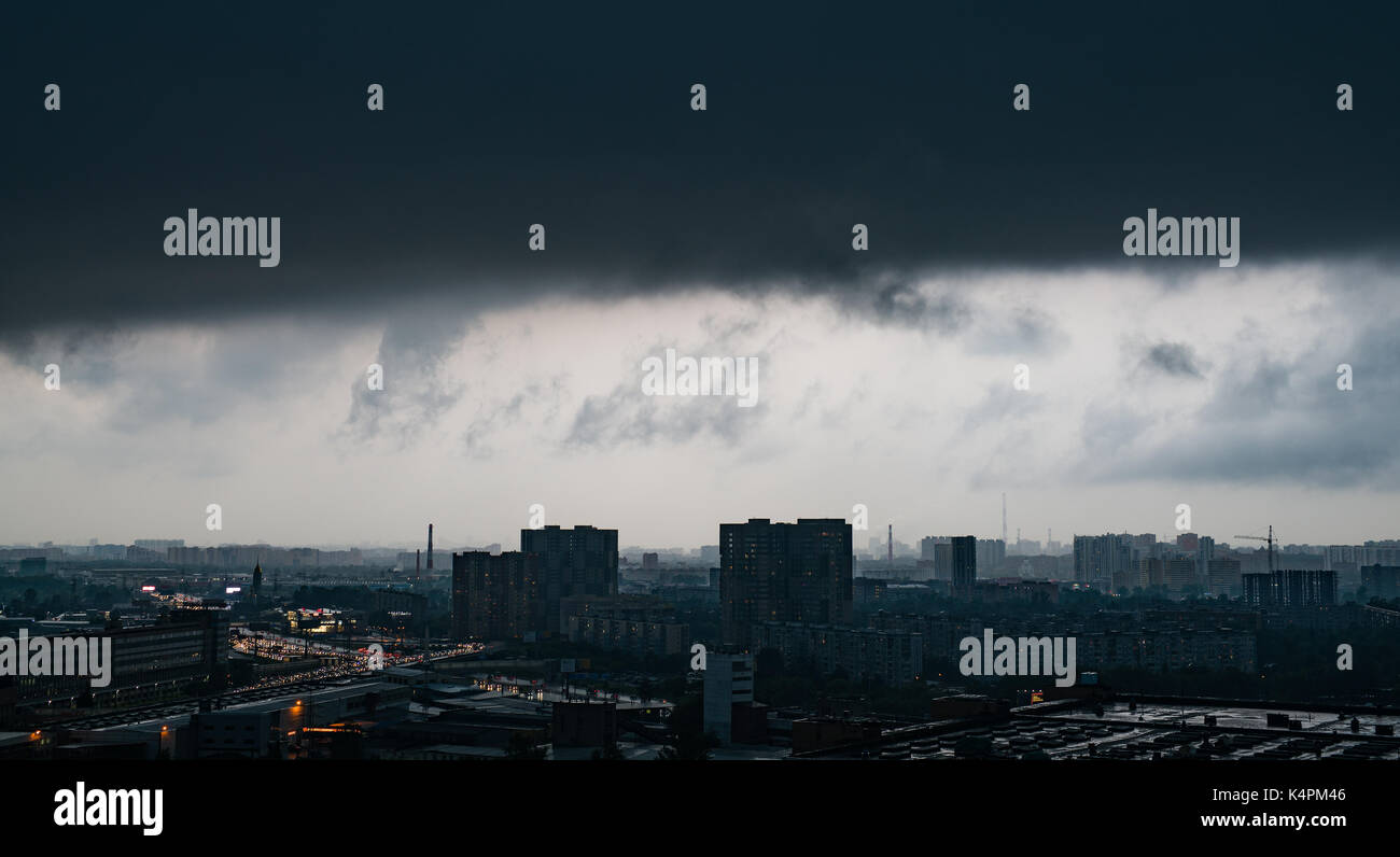 Dark storm dramatische Wolken über große Stadt. Moment vor Regen und Wind. Stockfoto