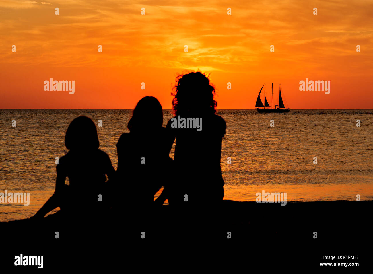 Mutter und zwei Töchtern beobachten Sie den Sonnenuntergang am Sand Key Park, Clearwater Beach, Florida, USA. Stockfoto