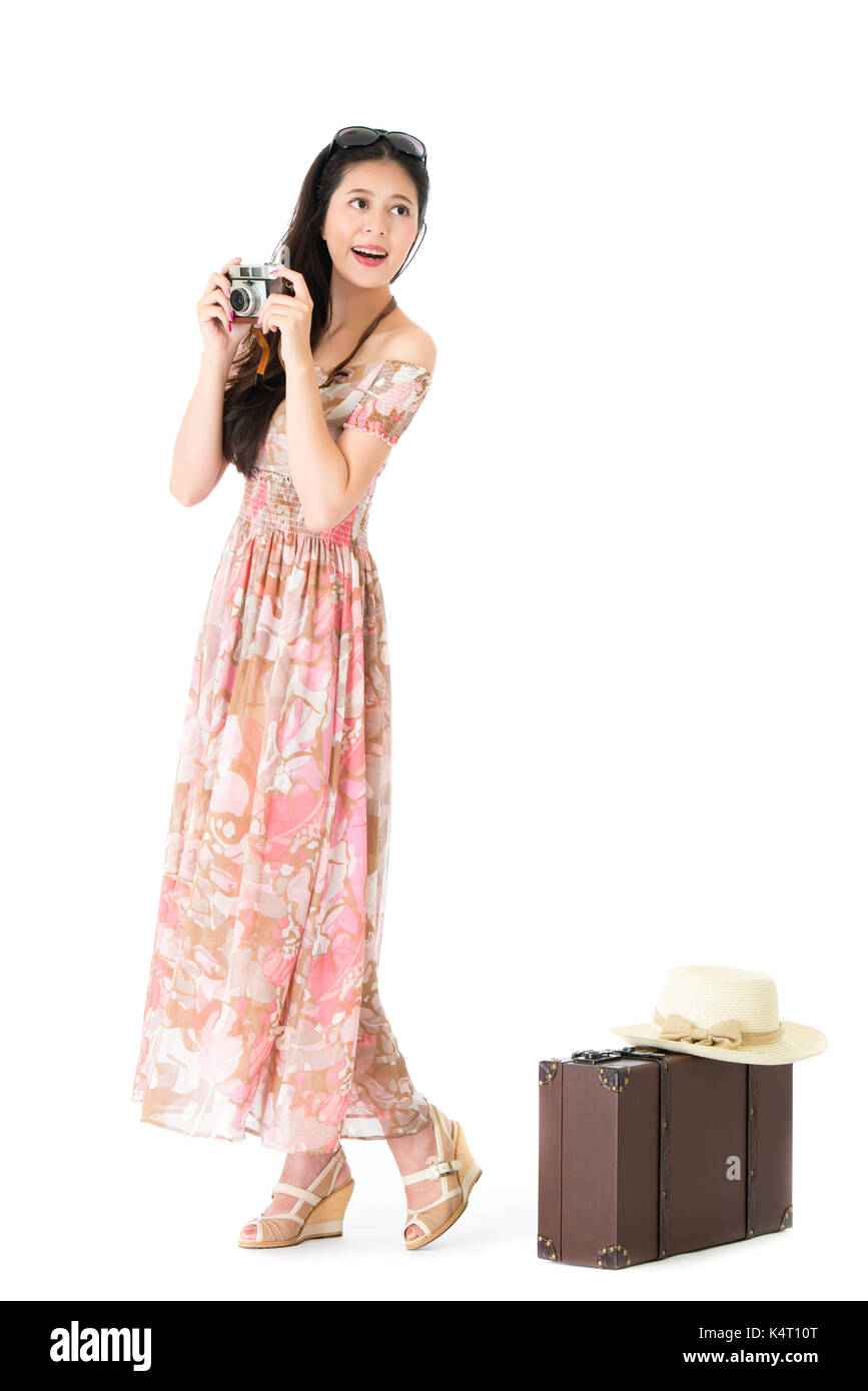 Elegante attraktive Frau mit retro Kamera auf der Suche nach Landschaften und die persönlichen Gepäck Koffer auf weißem Hintergrund. Stockfoto