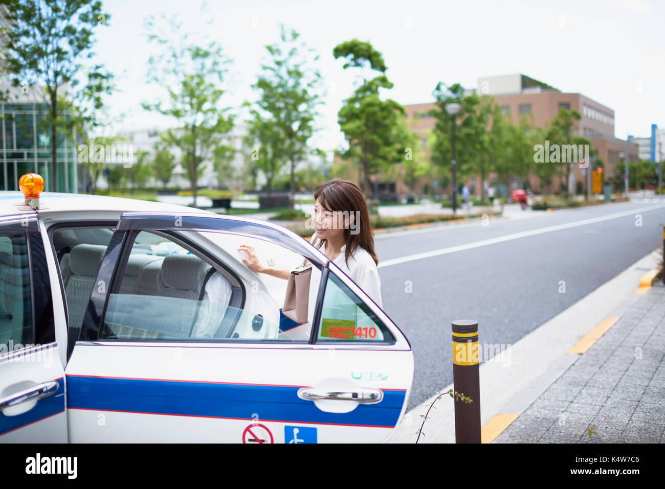 Junge japanische Frau reiten ein Taxi Downtown Tokyo, Japan Stockfoto