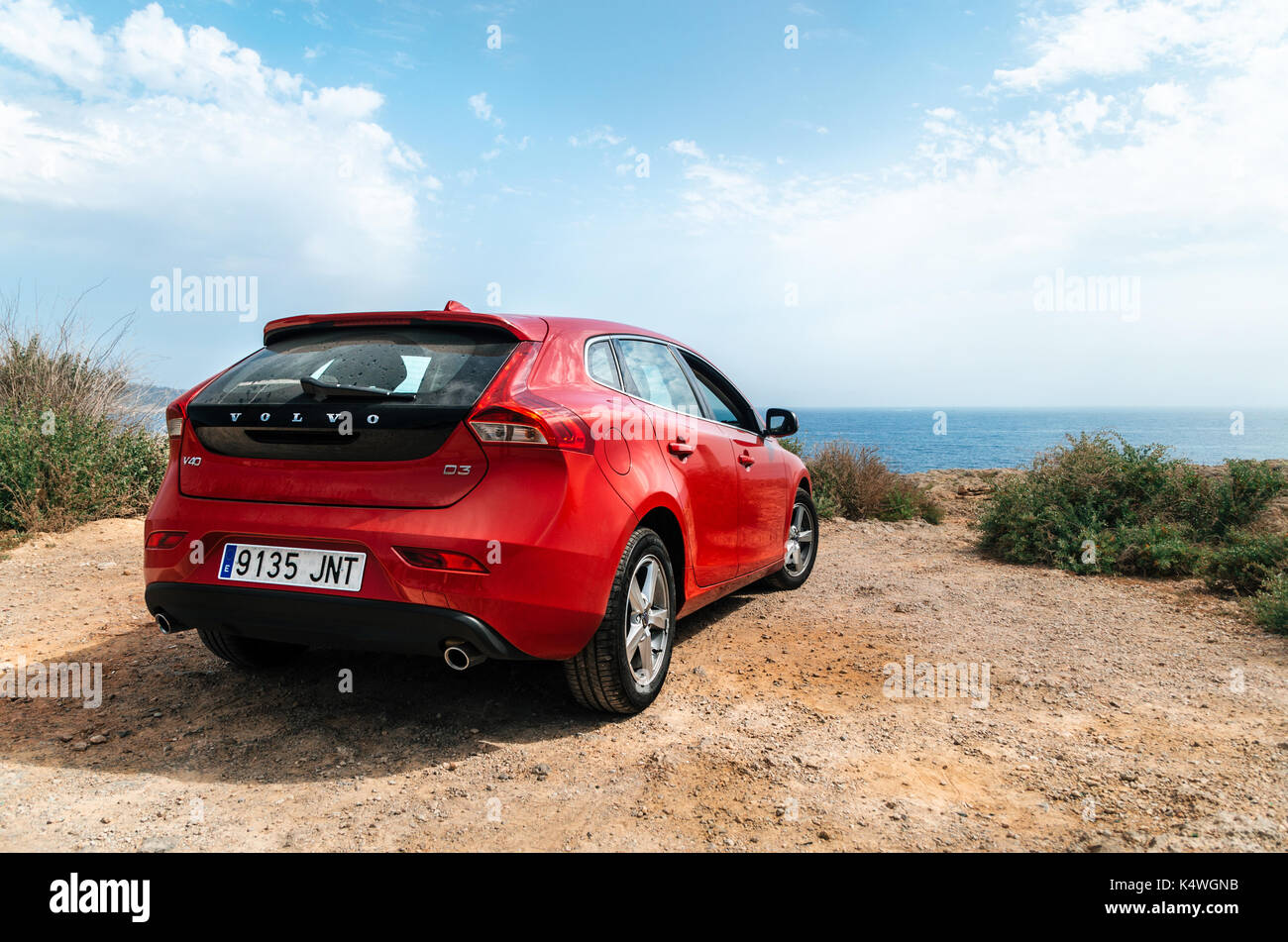 Santa Ponsa, Mallorca, Spanien - 28. Mai 2015: Rotes Auto Volvo V40 steht auf dem Rand einer Klippe vor dem Mittelmeer. Morro d'en Pere Joan b Stockfoto