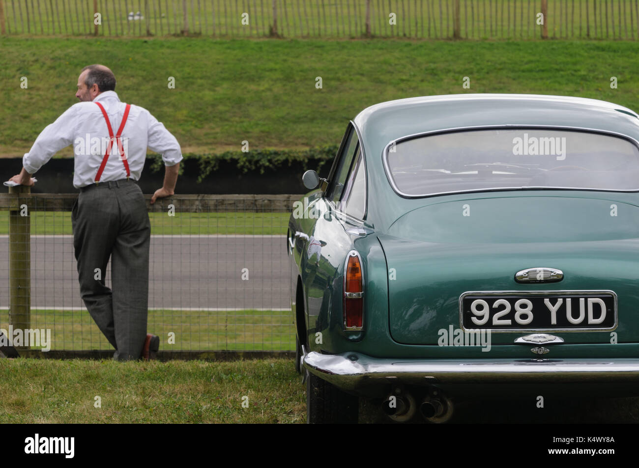 Klassischer Aston Martin und Mann in roten Klammern in Goodwood Revival Stockfoto