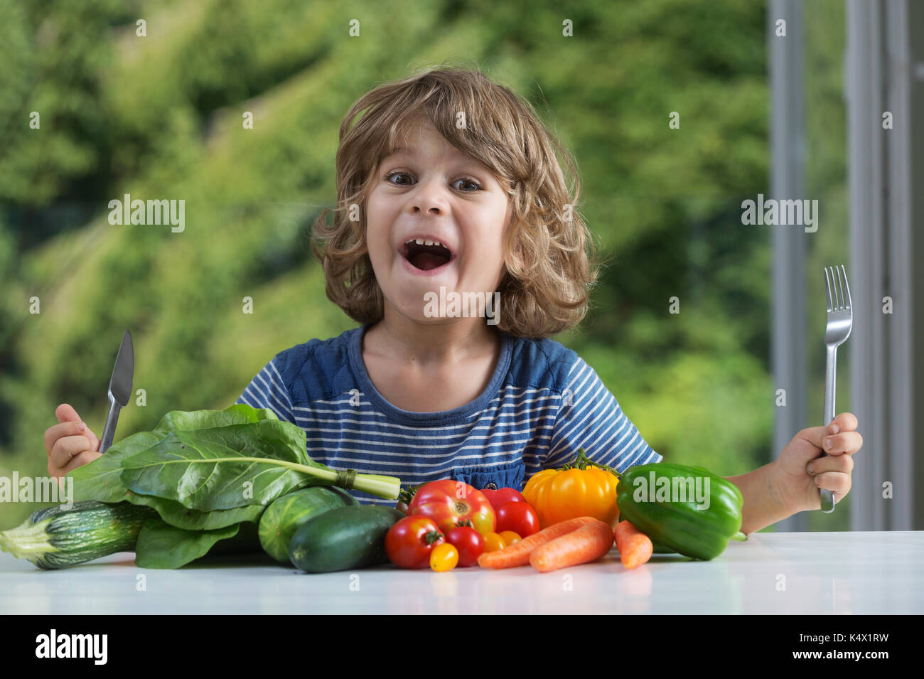 Cute little boy am Tisch über Gemüse essen aufgeregt sitzen, schlechte oder gute Essgewohnheiten, Ernährung und gesundes Essen, zeigt Emotionen Konzept Stockfoto
