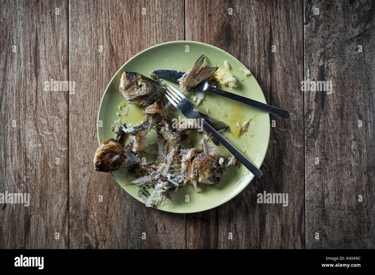 Fisch auf dem Teller mit Messer und Gabel beiseite stellen. Essensreste, Hausmüll entsorgt. Stockfoto