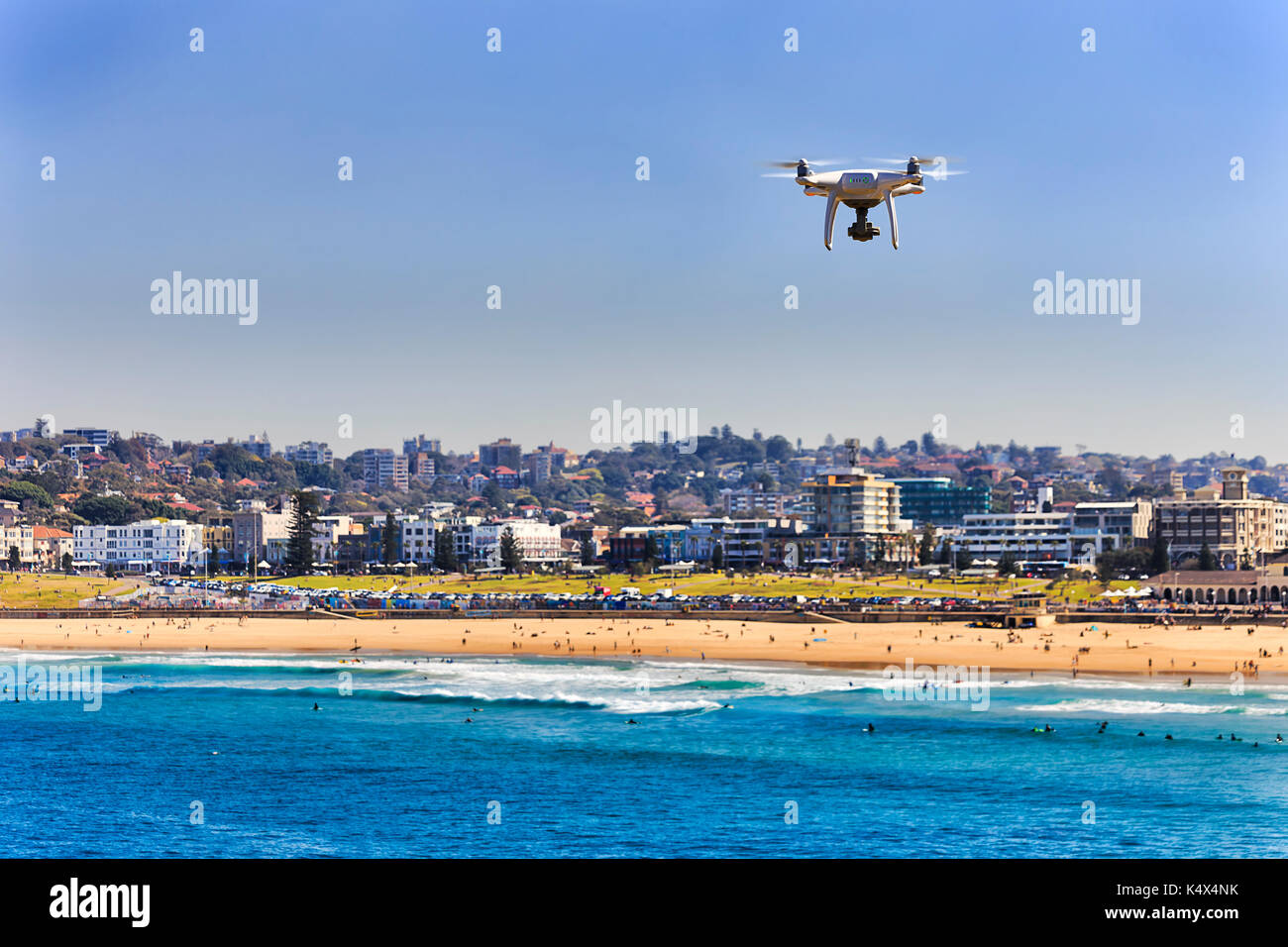 Fliegenden quadrocopter über Sand Linie der berühmten australischen Bondi Beach in Sydney. Aktive Menschen Schwimmen, Surfen und Entspannen im ikonischen Touristische destinat Stockfoto