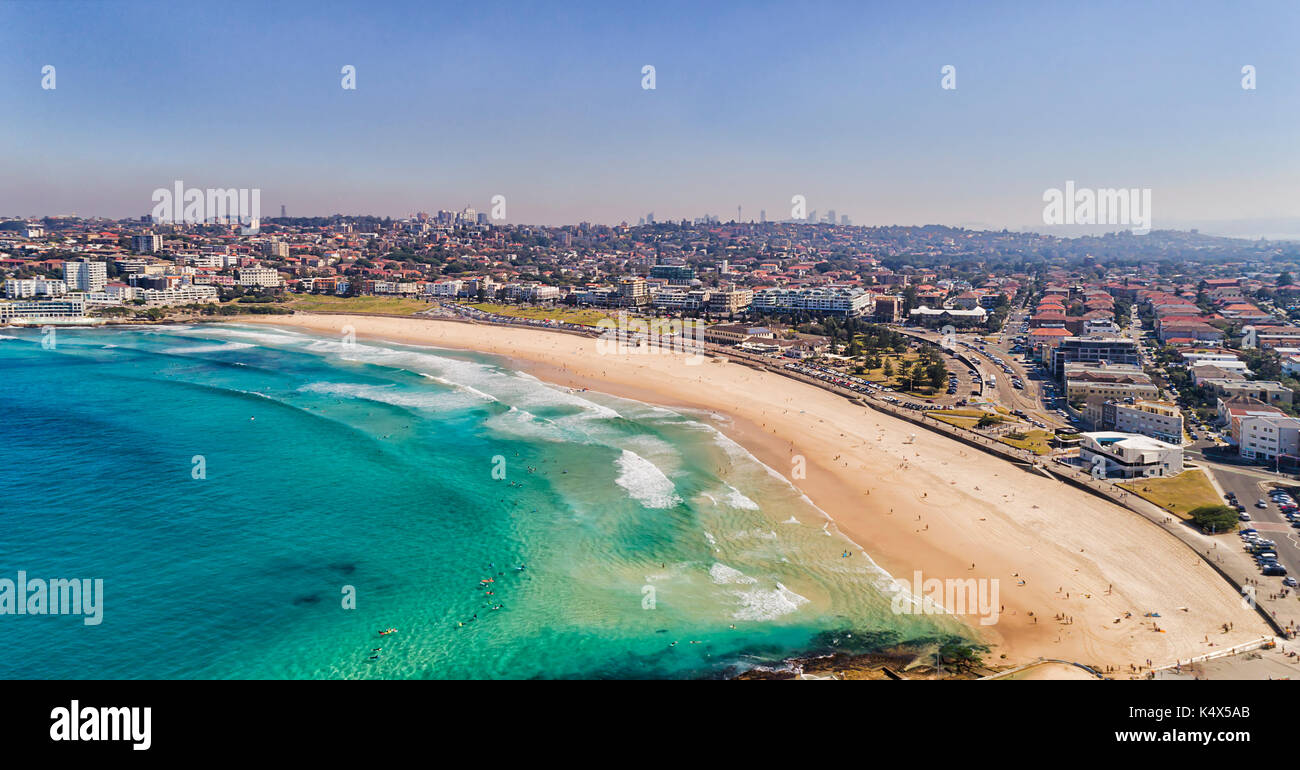 Unberührte klares Wasser von Sydney Bondi Strand mit hellem Sand und CBD Türme am Horizont in Antenne kurz oberhalb des Strandes. Stockfoto