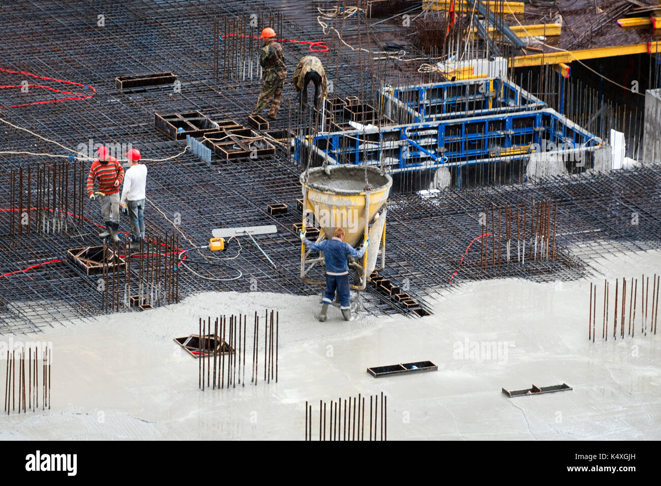 Bau der Grundstein des neuen Gebäudes. Antenne Blick von oben auf die Baustelle Arbeitnehmer Nivellierung Zement in der Baustelle. Stockfoto