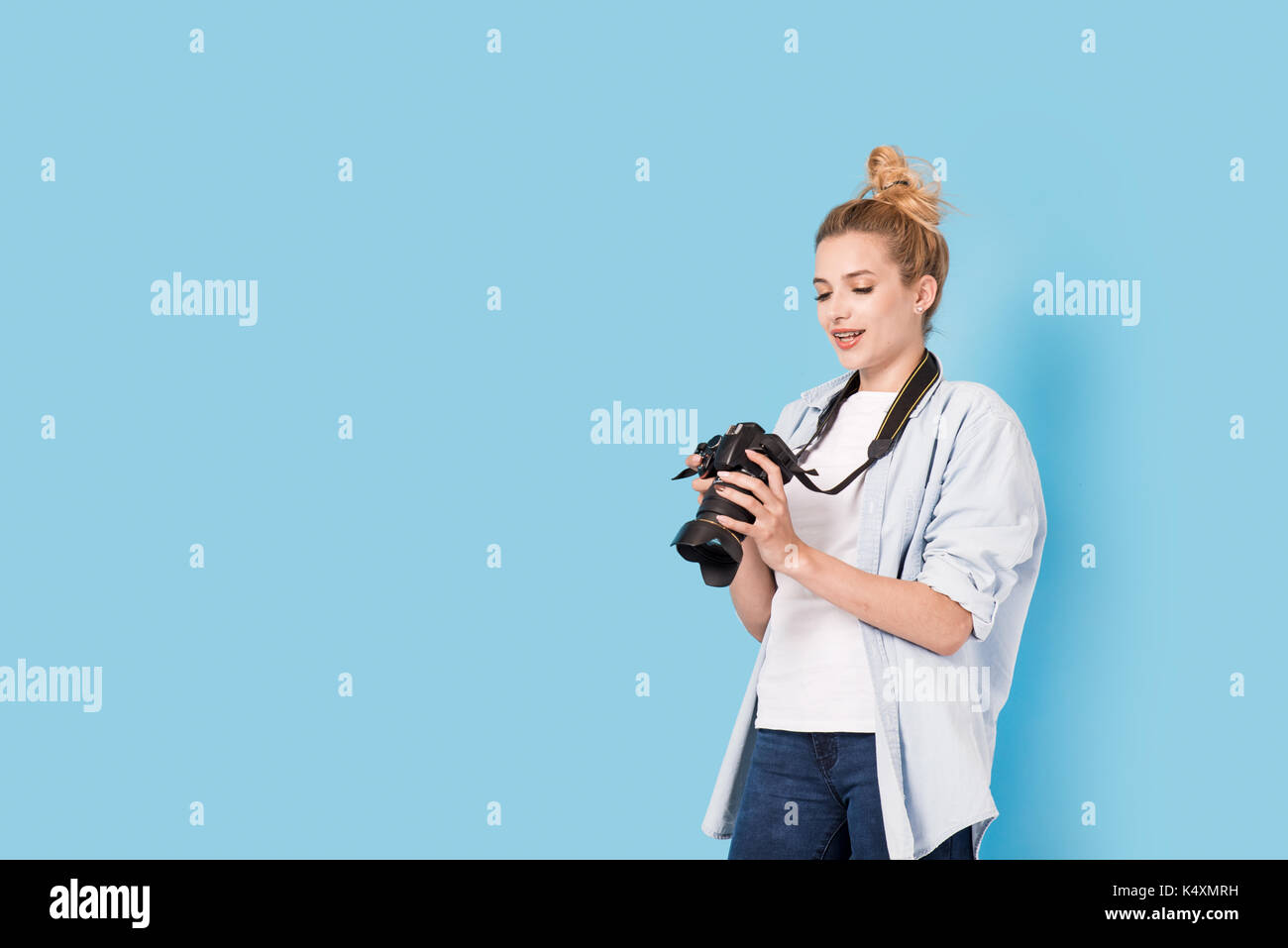 Fotografin ist über ihre Arbeit zufrieden. Modell isoliert auf einem blauen Hintergrund mit Kopie Raum Stockfoto