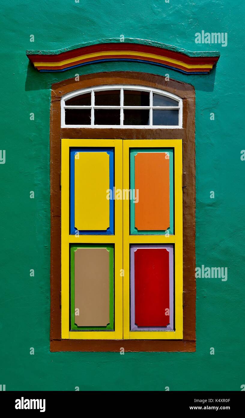 Traditionelle indische Fenster mit bunten Fensterläden in einem orange Wand eines shop Haus in Little India, Singapur. Stockfoto