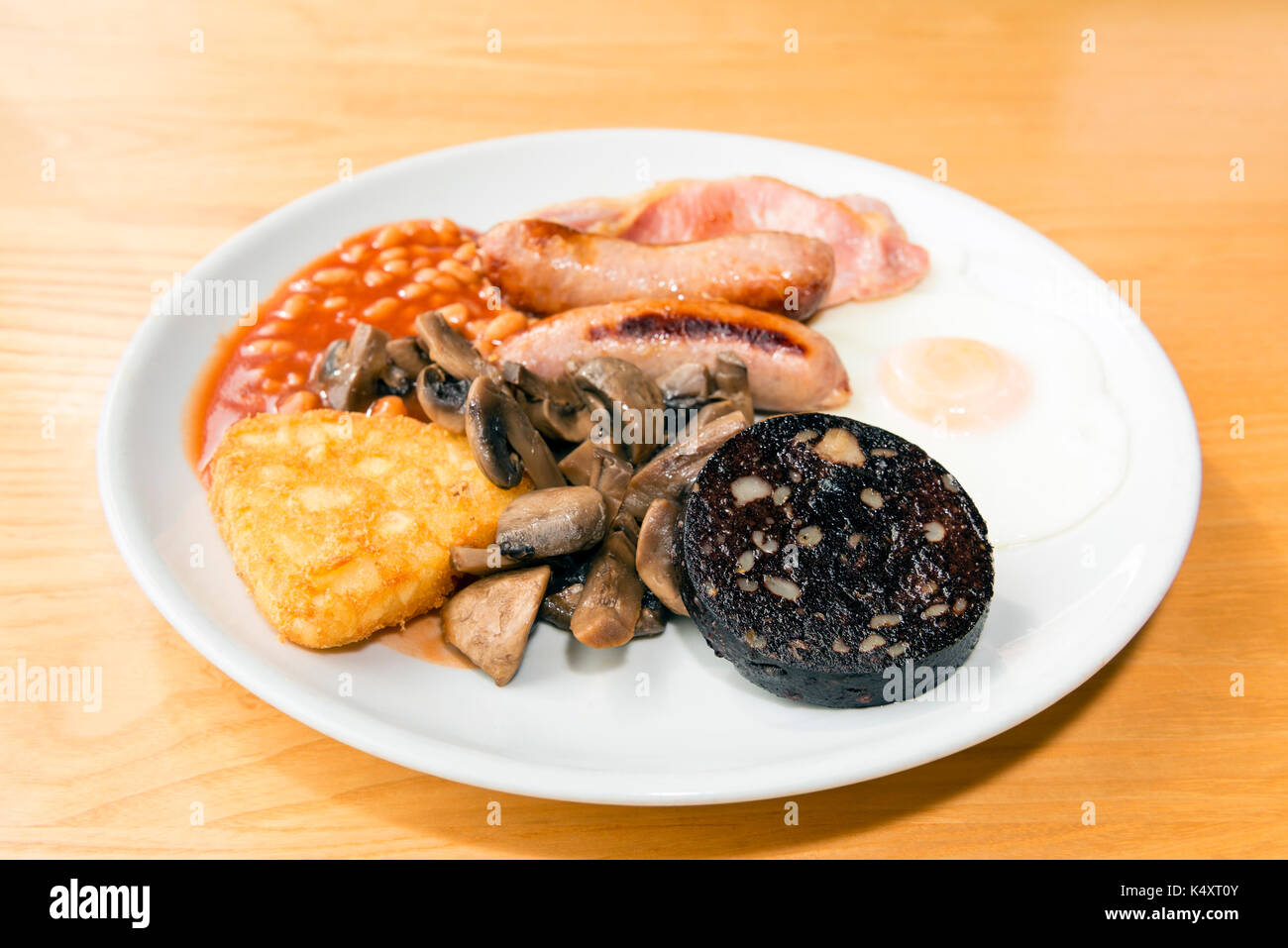 Englisches Frühstück mit Blutwurst, Würstchen, Speck, Hash Brown, Großbritannien. Stockfoto