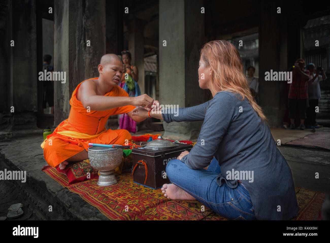 Ein Tourist an der Tempelanlage Angkor Wat erhält ein Segen von einem buddhistischen Mönch. Die Tempelanlage ist in Siem Reap, Königreich Kambodscha entfernt. Stockfoto