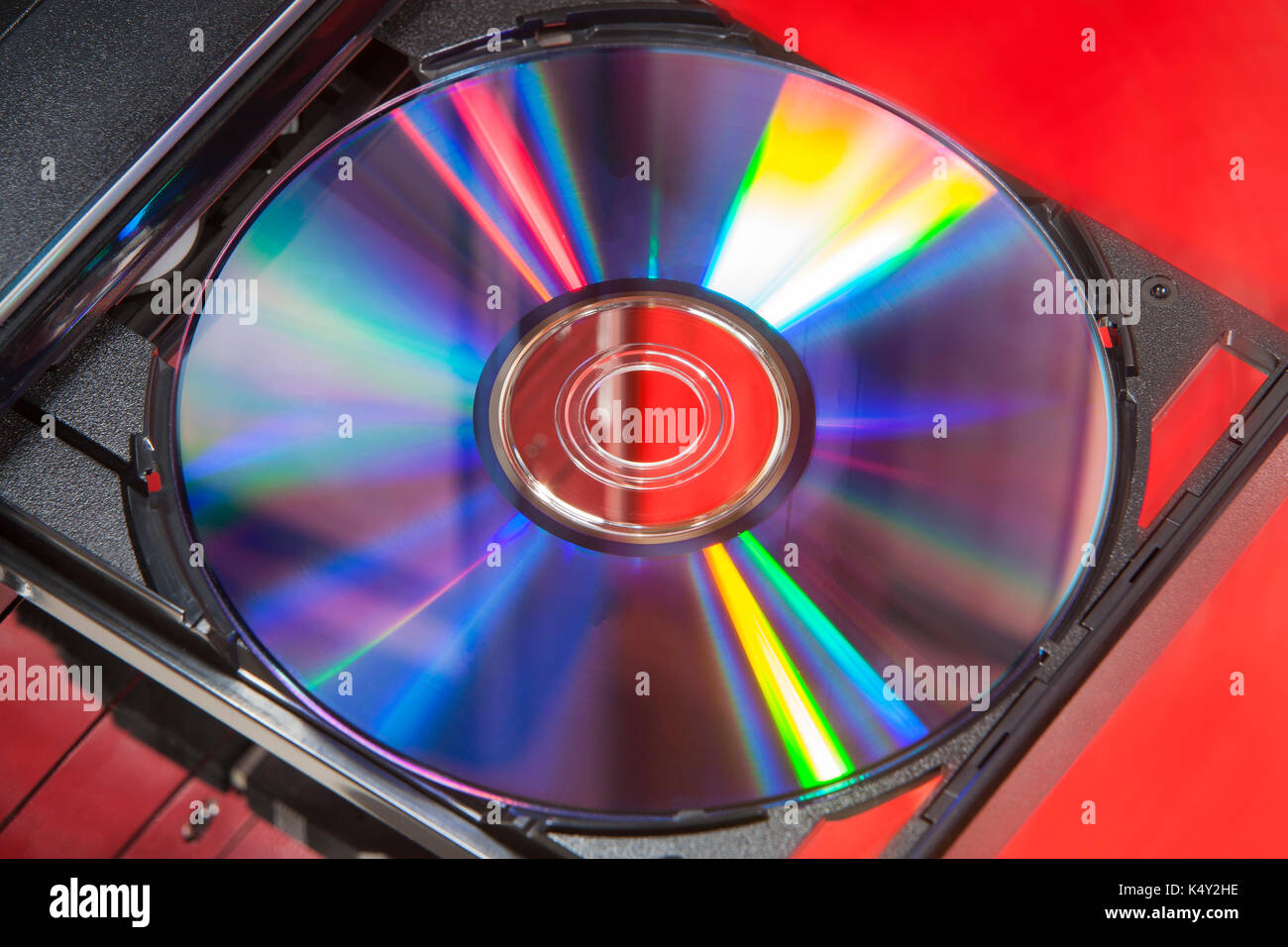 DVD-Disc im Player von einem Desktop Computer mit einem roten Hintergrund Stockfoto