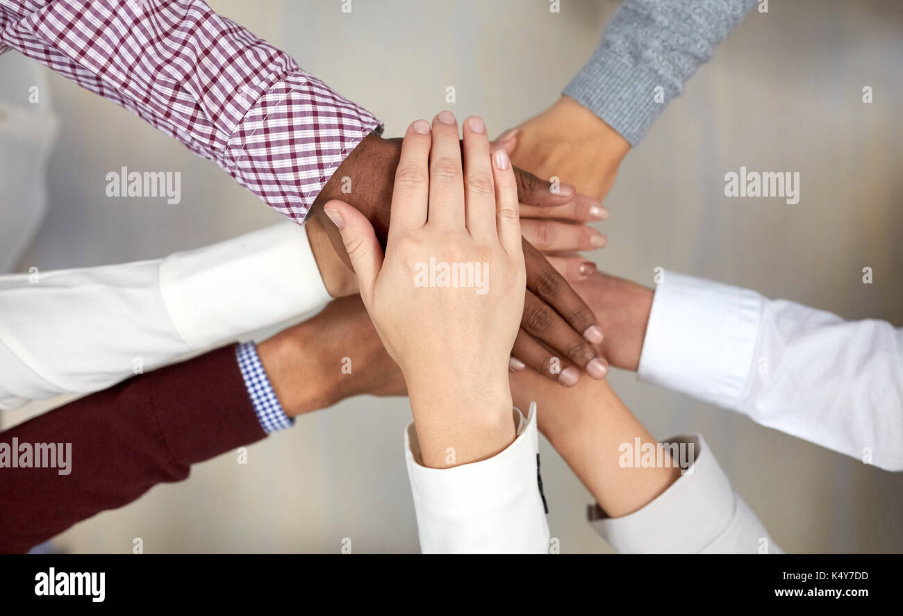 Business-Team mit Händen an der Spitze im Büro Stockfoto