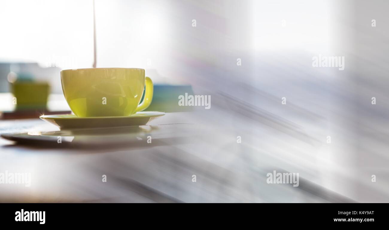 Digital composite Grün Kaffeetasse auf dem Schreibtisch und verschwommen weiß Übergang Stockfoto