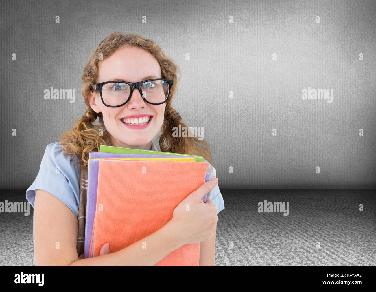 Digital composite von Nerd Frau mit Büchern in grauen Raum Stockfoto