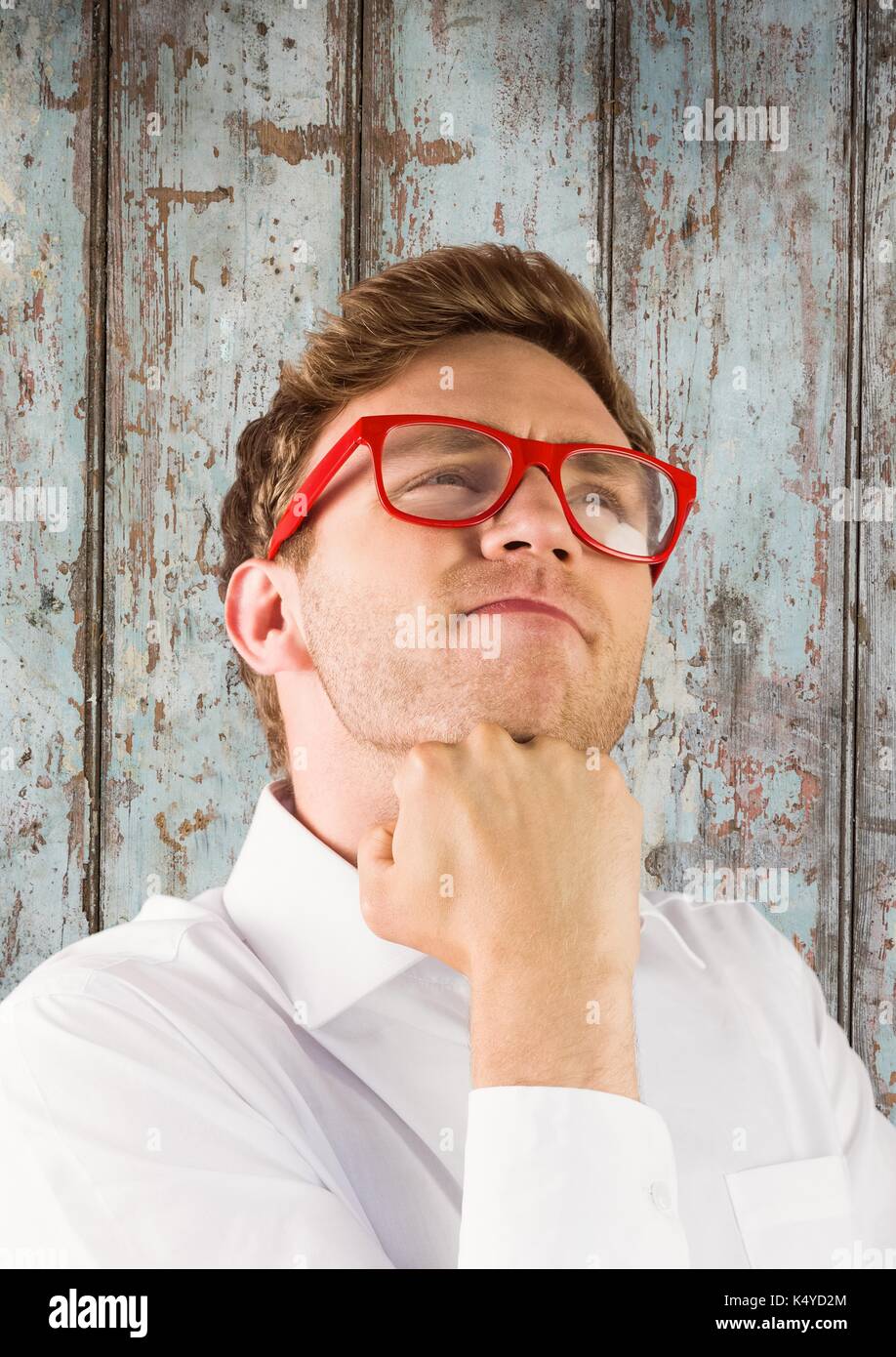 Digital composite von Nerd Mann Denken gegen Holz Panel Stockfoto