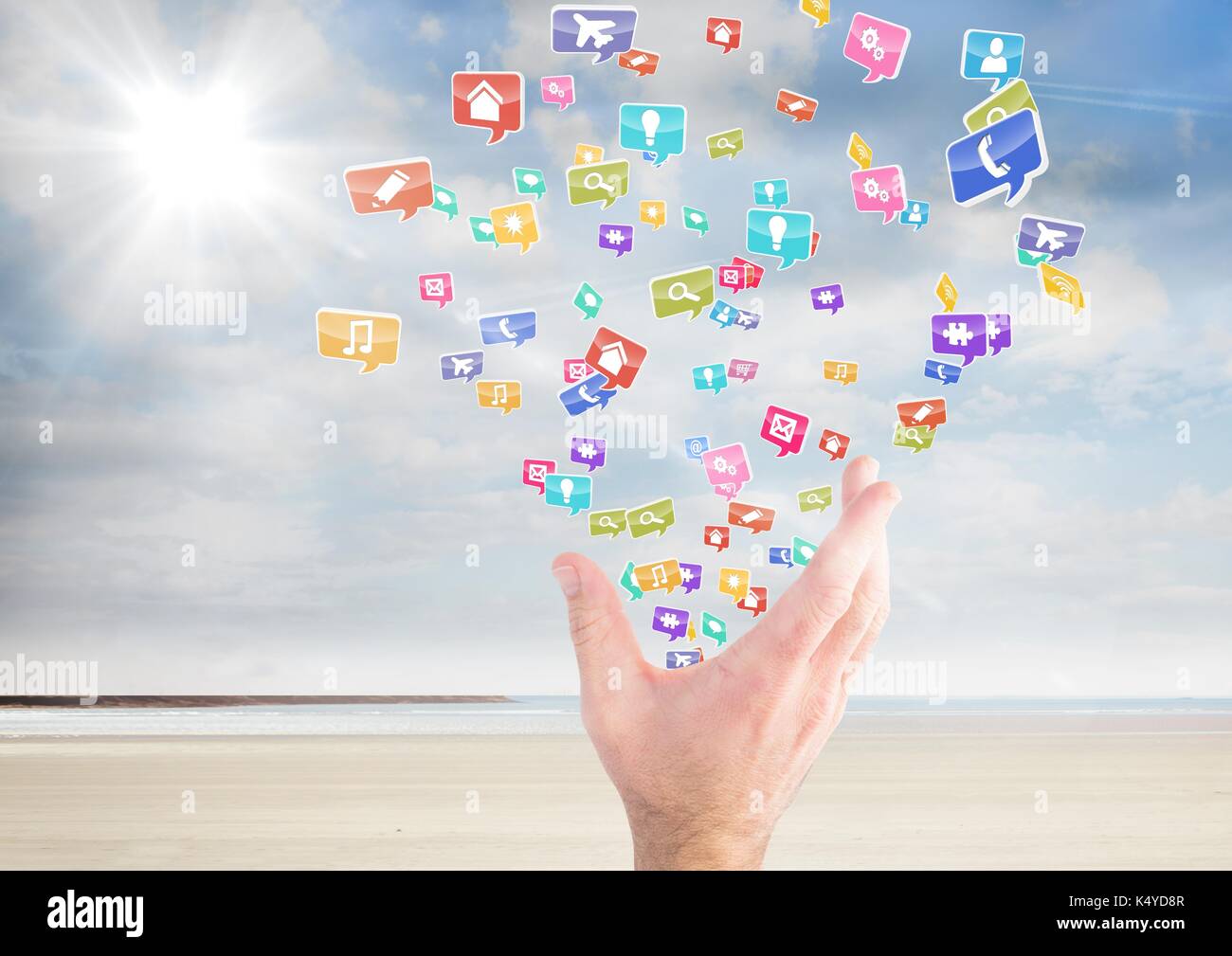 Digital composite von Hand mit Anwendungssymbole aus es am Strand Stockfoto