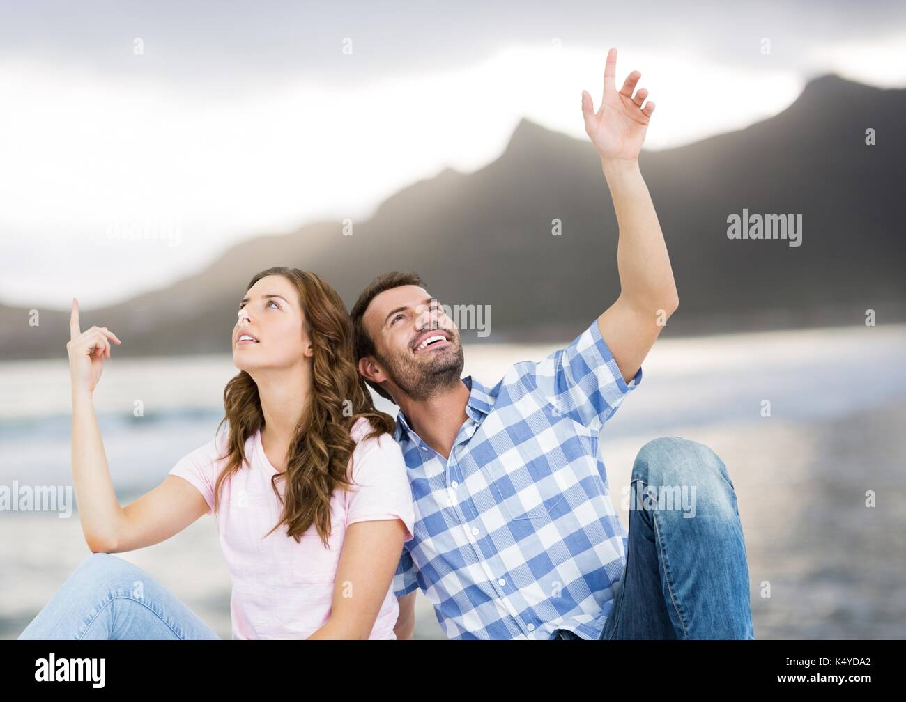 Digital composite von Paar und zeigen gegen blurry Strand Stockfoto