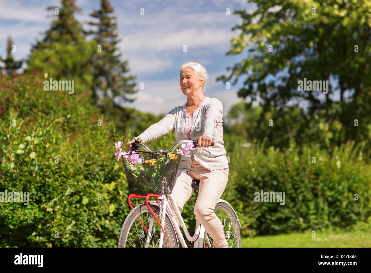 Gerne ältere Frau Reiten Fahrrad am Sommer, Park Stockfoto