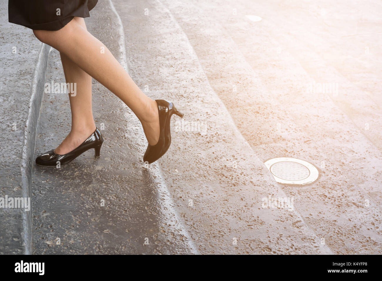 Fuß und Bein der Geschäftsfrau mit schwarzen High Heel Schuhe auf der Treppe im Freien. junge Frau gehen im Büro zu arbeiten. Stockfoto