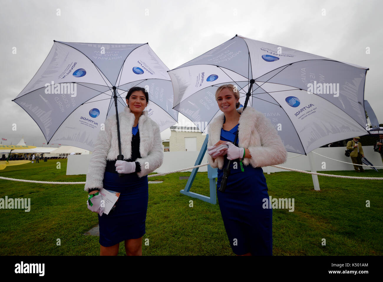 Weibchen beim Goodwood Revival 2017 in Periodenkleidung mit Regenschirmen. Retro-Event bei schlechtem Wetter Stockfoto