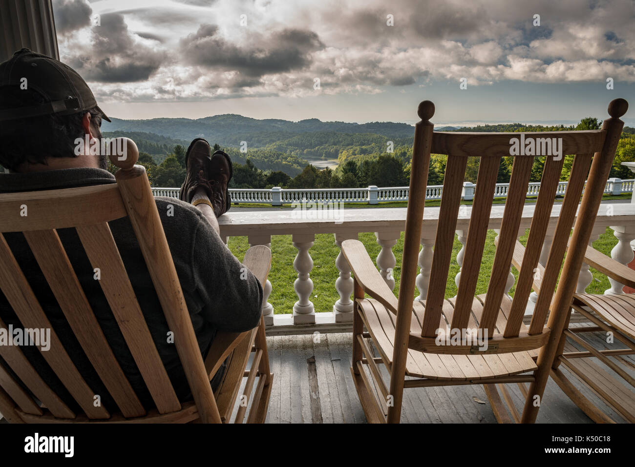 Füße hochlegen Relaxen Schaukelstuhl Veranda - Fantastische Aussicht, Wolken. Südlichen Berg Leben. Holz- Wippe, auf der Veranda mit Blick auf den See Stockfoto