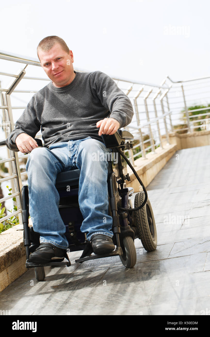 Mann im Rollstuhl sitzt in der Nähe der Geländer Stockfoto