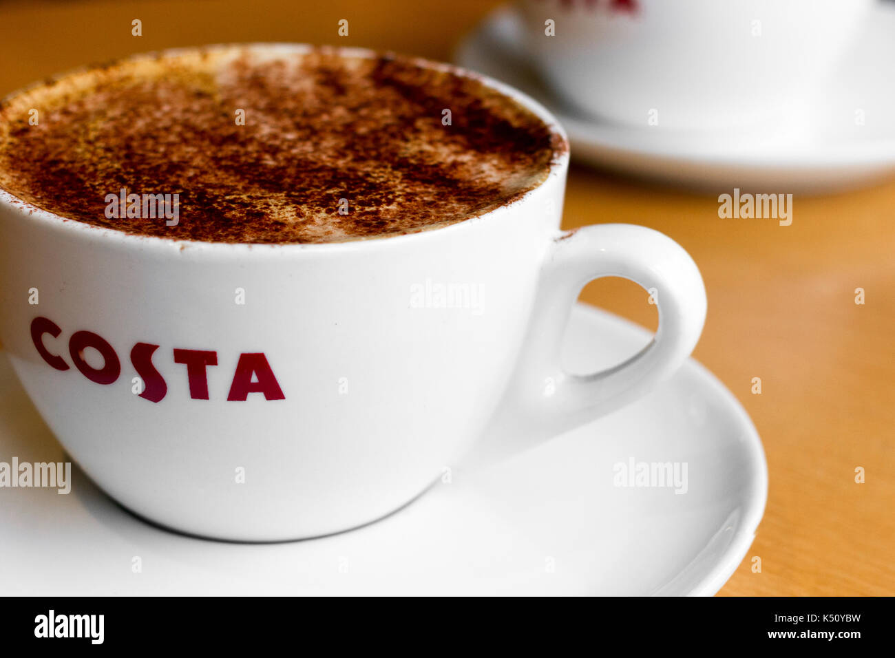 Tasse Kaffee (mittlere Mokka Kaffee mit Schokolade abstauben) in einer britischen Costa Coffee Shop Stockfoto