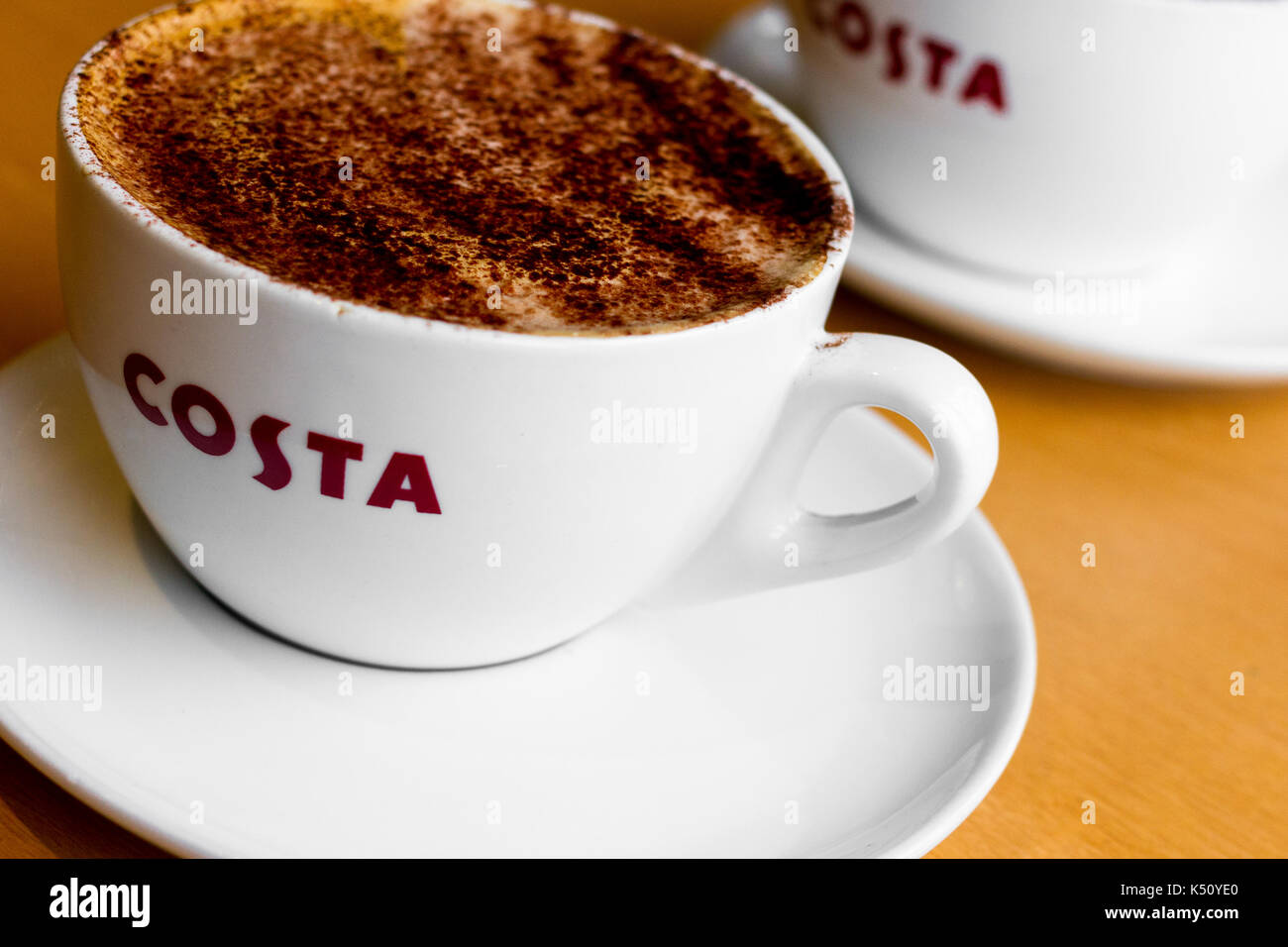 Tasse Kaffee (mittlere Mokka Kaffee mit Schokolade abstauben) in einer britischen Costa Coffee Shop Stockfoto