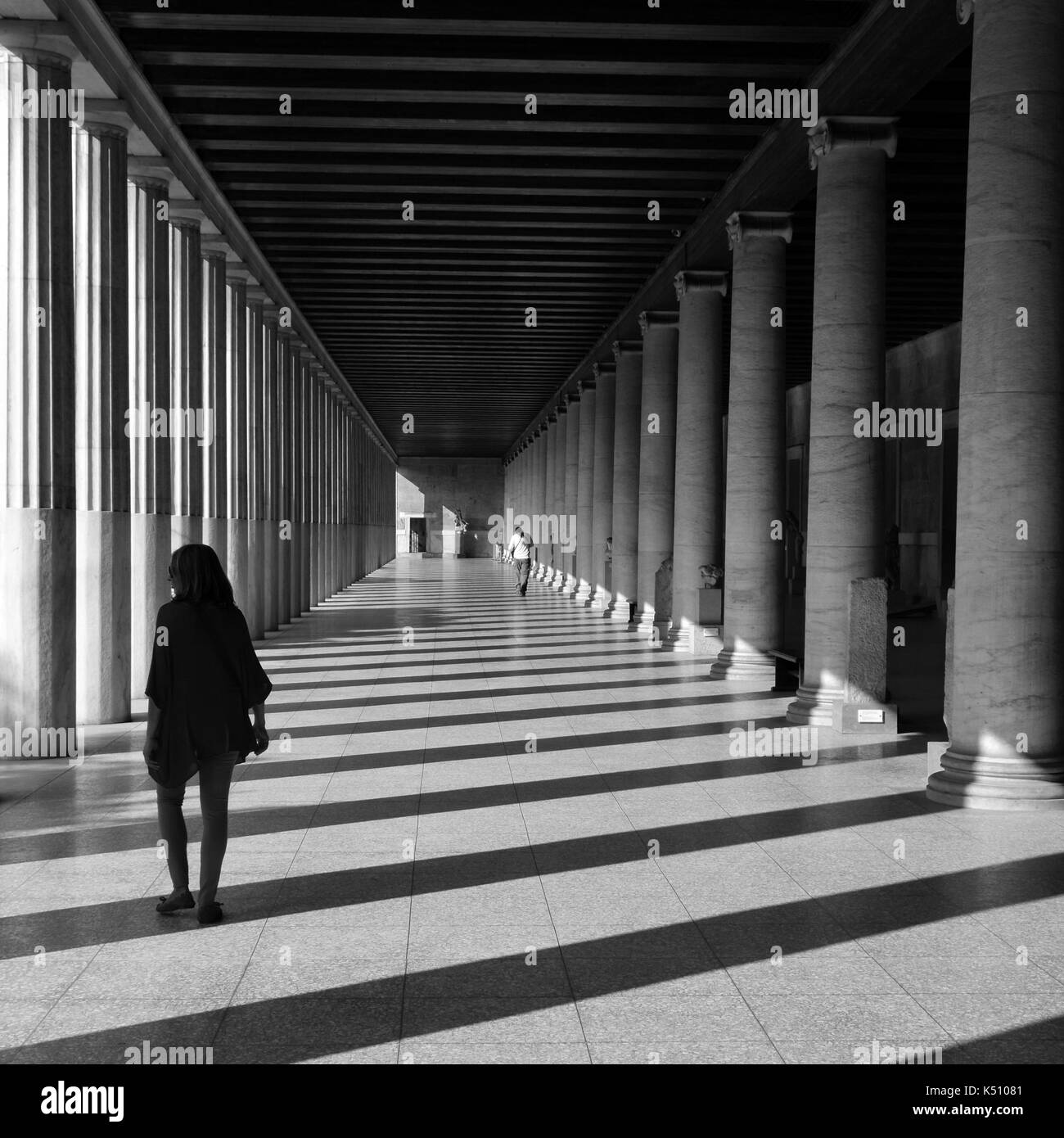 Athen, Griechenland - Oktober 14, 2015: Die Menschen in Stoa attalos an den antiken Agora. Licht und Schatten durch Marmorsäulen abstrakte Architektur schwarz ein Stockfoto