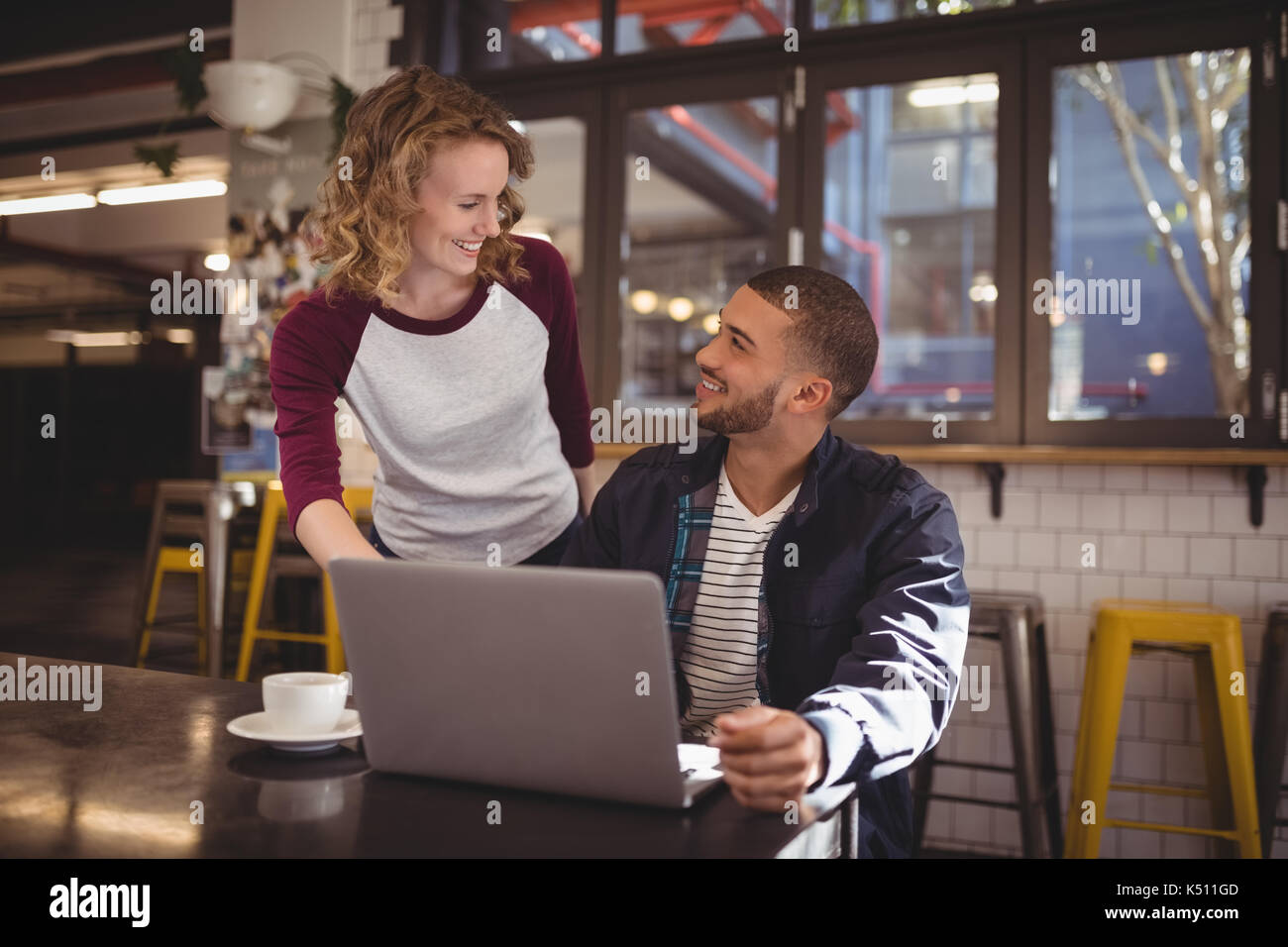 Lächelnde junge Frau und Mann im Coffee Shop Stockfoto