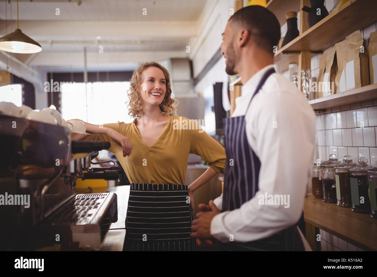 Lächelnden jungen Kellner und Kellnerinnen stehen, Espressomaschine, Kaffee shop Stockfoto