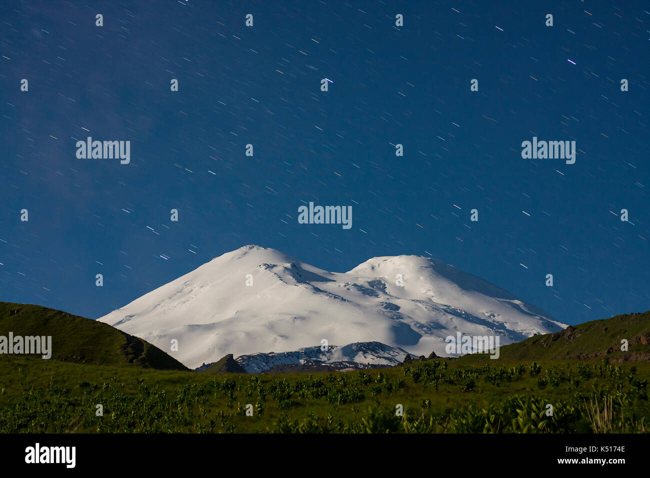 Snowy Mountain Elbrus (5642 m) im Mondlicht und Star Tracks bei Nacht Stockfoto