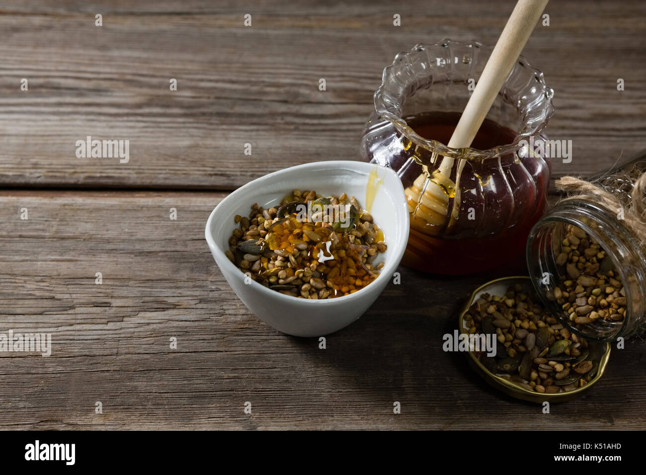 Close-up von Frühstückszerealien und Glas Honig auf hölzernen Tisch Stockfoto