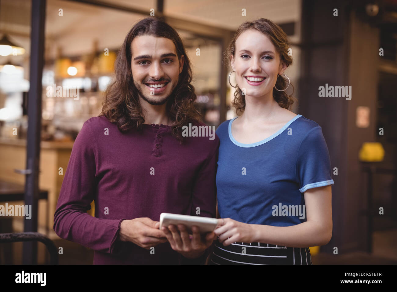 Portrait von selbstbewussten jungen Kellnerin und Mann mit digitalen Tablet im Coffee Shop Stockfoto