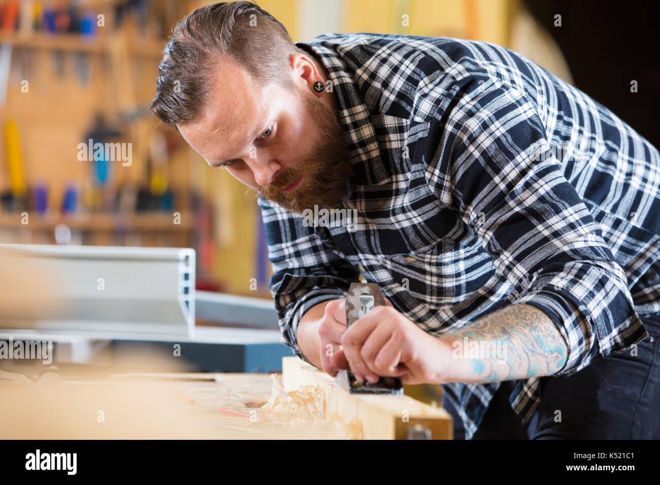 Tischler arbeitet mit dem Flugzeug auf Holz Plank in Werkstatt Stockfoto