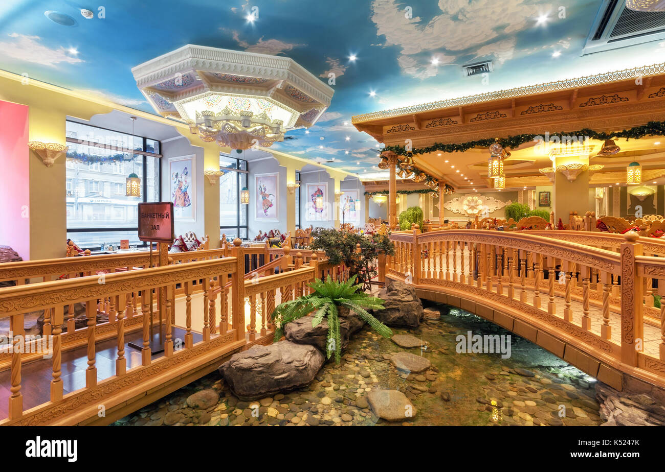 Der Innenraum des Deluxe Restaurant der usbekische Küche - babay Club im orientalischen Stil. Teich und hölzerne Brücke in der Stockfoto