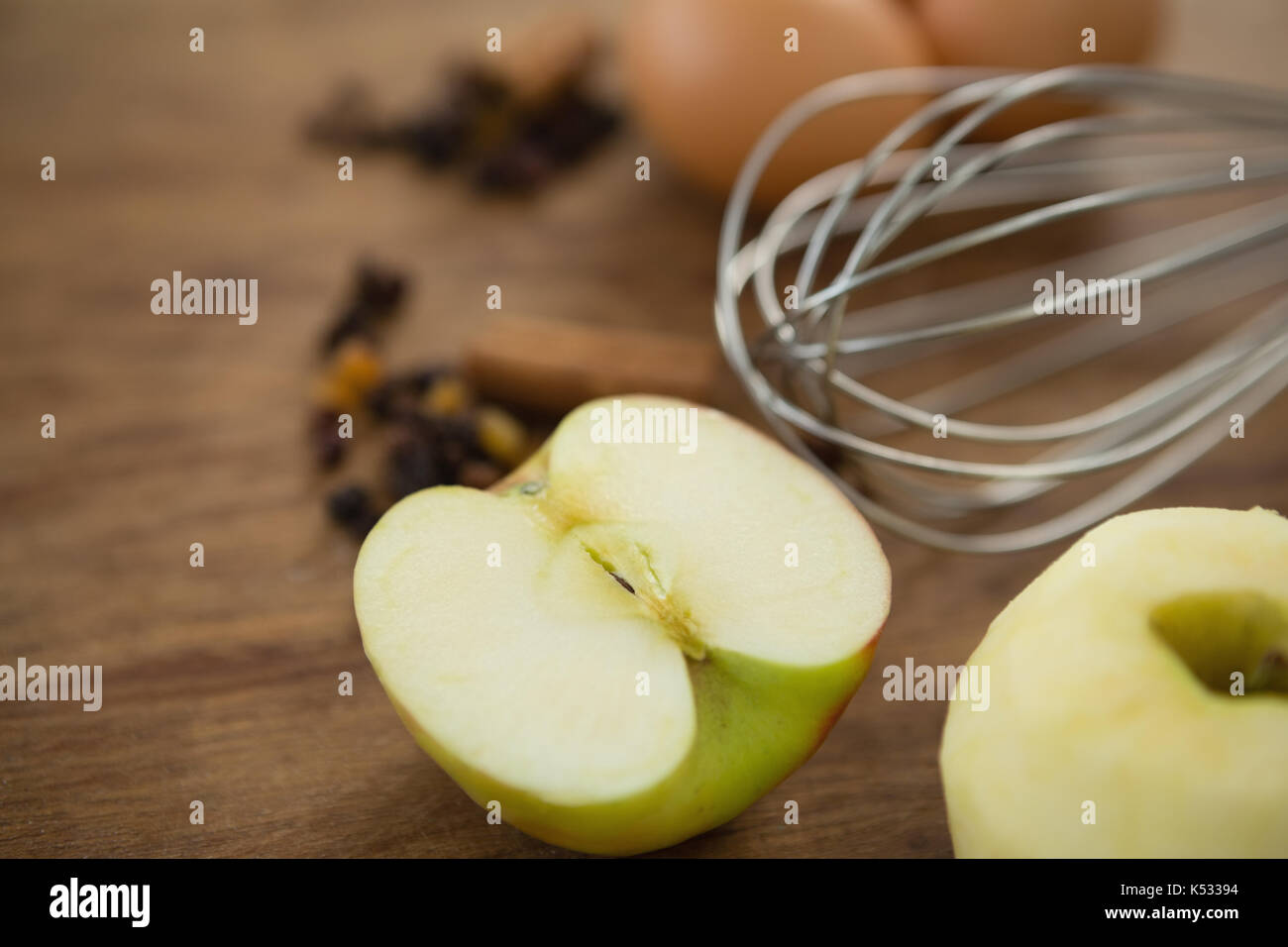 Nahaufnahme von Kabel Schneebesen durch Eier Granny Smith Apfel auf dem Tisch Stockfoto