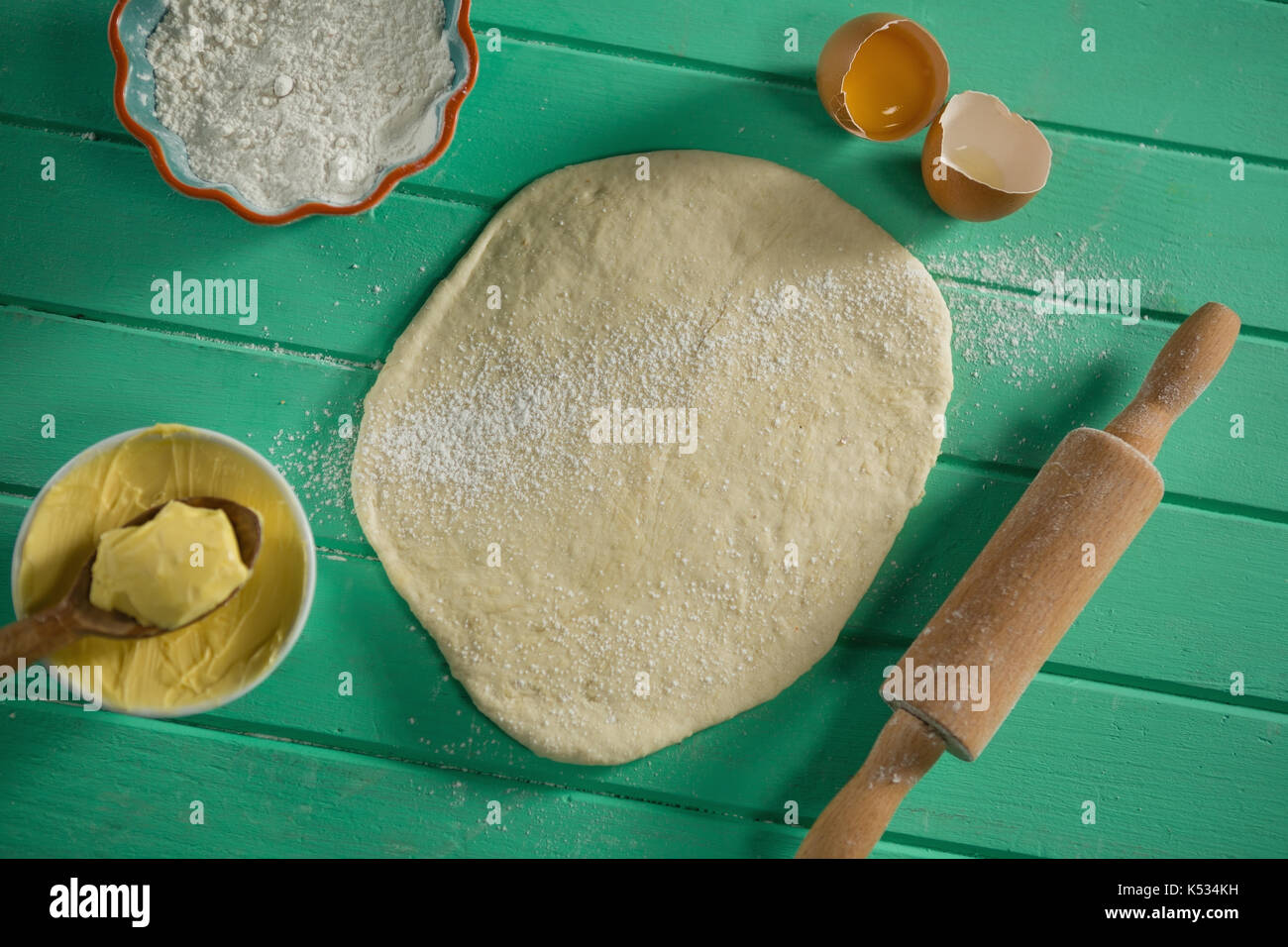 Ansicht von oben von gerollten Teig mit Rolling Pin und Zutaten auf Tisch Stockfoto