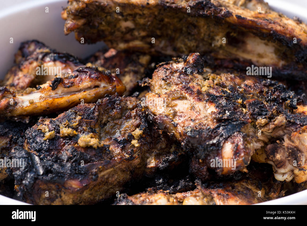 Nahaufnahme von gegrillten würzigen jerk chicken über Holzfeuer gekocht. Stockfoto