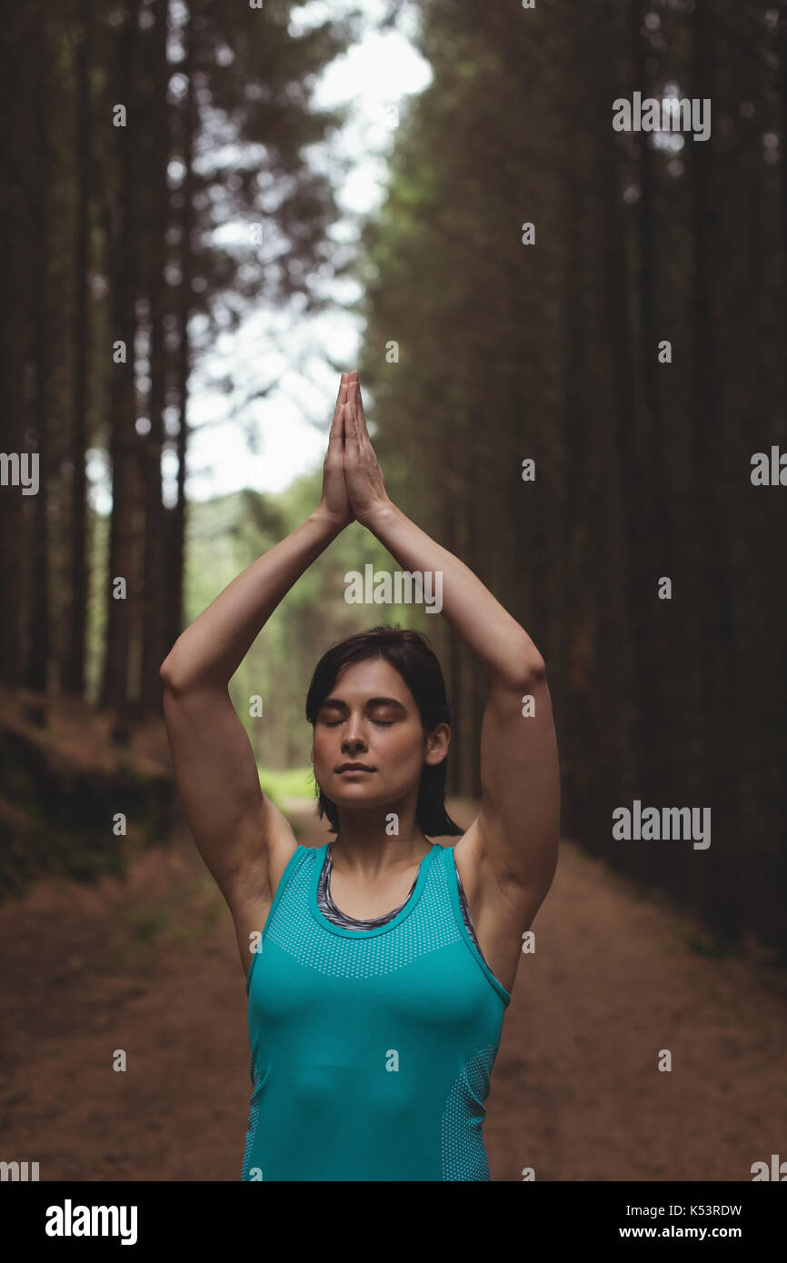 Frau durchführen Yoga im Wald an einem sonnigen Tag Stockfoto