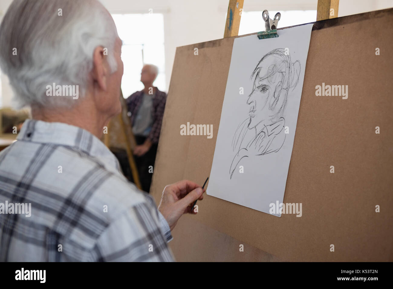 Der ältere Mann Zeichnung Skizze der Frau auf Papier in der Kunst Klasse Stockfoto