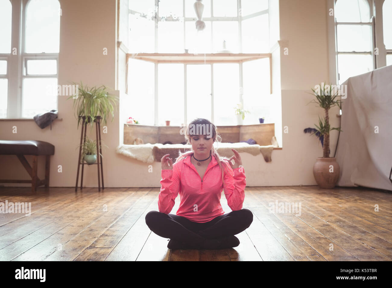 Junge Frau Yoga auf Parkett im Studio Stockfoto