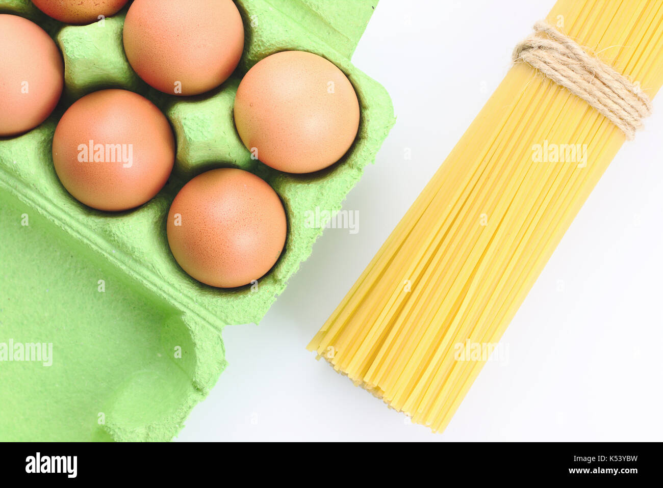Eier im Karton und Pappe ei Spaghetti auf weißem Hintergrund Stockfoto