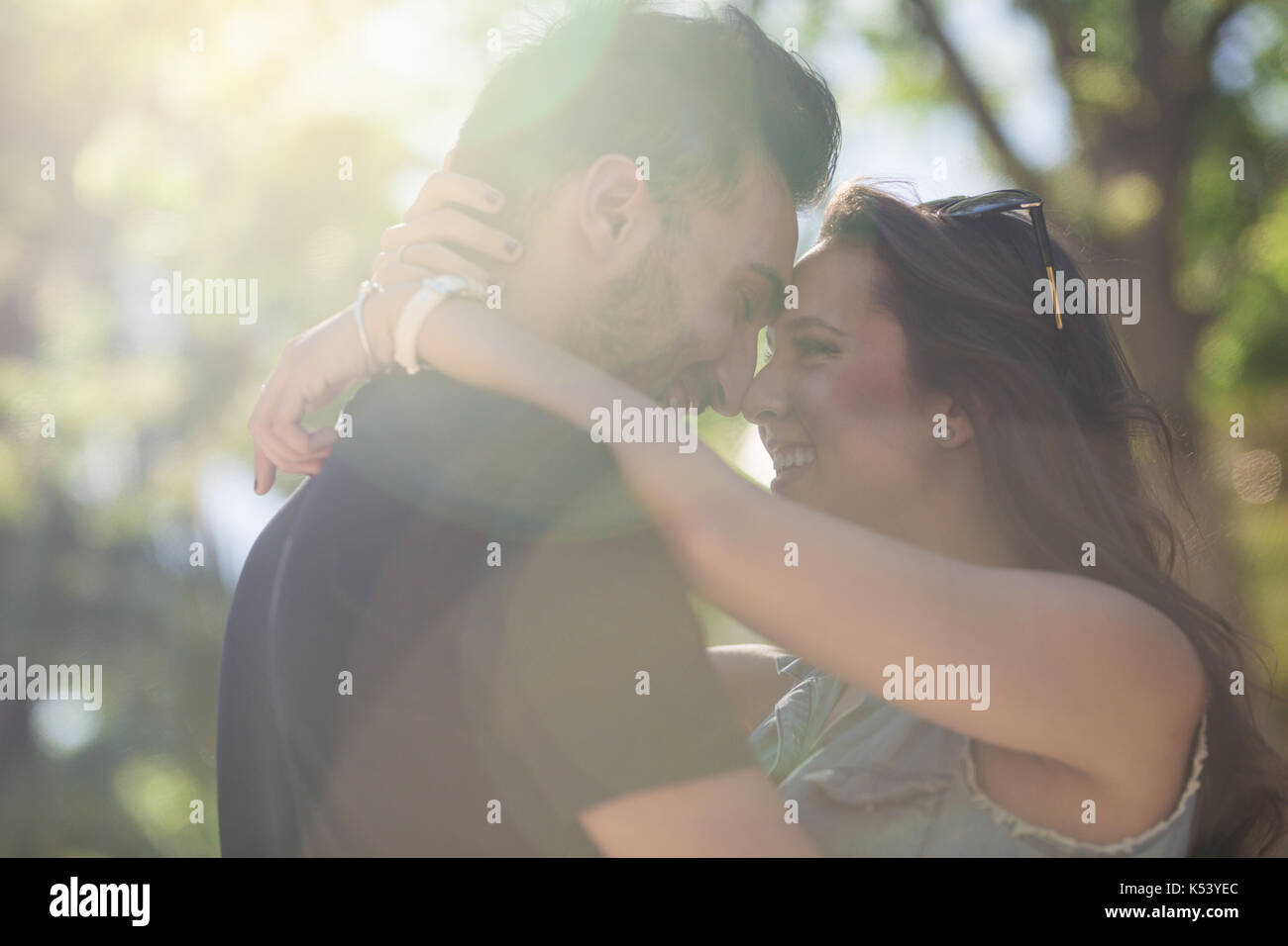 Porträt der jungen glückliches Paar in der Liebe lehnte sich auf jeden anderen Kopf im Sonnenlicht Stockfoto