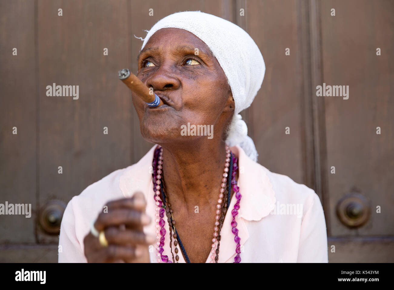 Alte Dame raucht eine kubanische Zigarre auf den Straßen von Havanna, Kuba in der Karibik Stockfoto