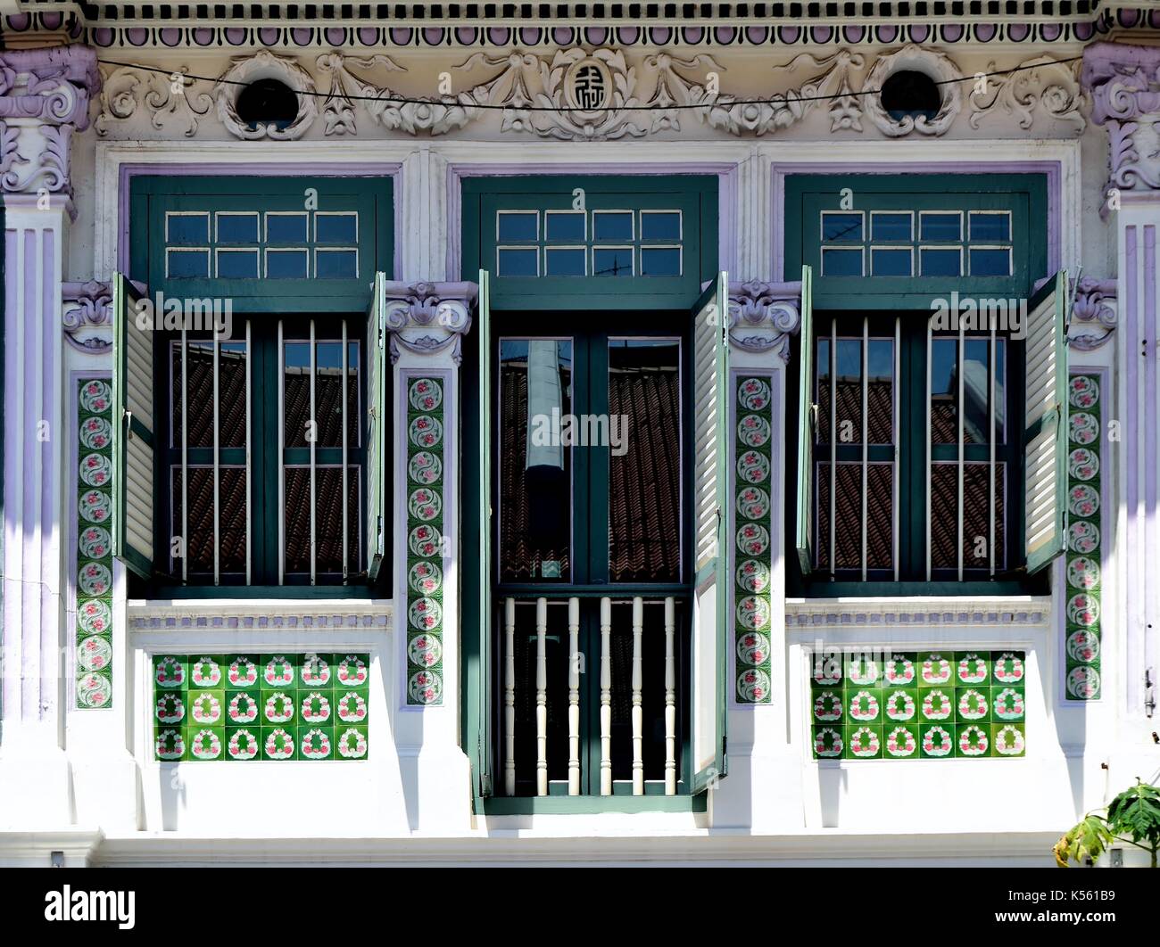 Traditionelle shop Haus außen mit grünen Lamellenfensterläden, kunstvolle Schnitzereien und original chinesischer Fliesen im Joo Chiat District von Singapur Stockfoto